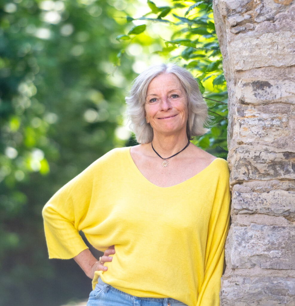 Sandra Jost, angelehnt an Mauer, gelbes Shirt